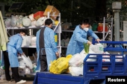北京一居民區因疫情被封後保安們卸下小區居民購買的食品袋。（2022年10月20日）