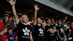 在香港舉行的2022年卡塔爾世界杯和2023年亞足聯亞洲杯預選賽第二輪香港對陣伊朗的比賽中，香港球迷身穿印有香港國旗黑色圖案的衣服抗議政府。 (2019年9月10日)
