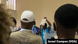 Uma delegada de mesa exibe um boletim de voto após início da contagem. Escola de São José de Cluny, Luanda. Angola