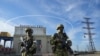 Des soldats russes gardent l'entrée de la centrale électrique de Kakhovka sur le Dniepr, dans la région de Kherson, dans le sud de l'Ukraine, le 20 mai 2022.