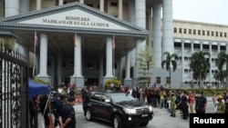 FILE - Former Malaysian Prime Minister Najib Razak leaves in a vehicle from Kuala Lumpur Court Complex after his second trial proceeding related to the 1Malaysia Development Berhad scandal, in Kuala Lumpur, Aug. 25, 2022. 