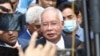 FILE - Former Malaysian Prime Minister Najib Razak, center, speaks to supporters outside at Court of Appeal in Putrajaya, Malaysia Tuesday, Aug. 23, 2022.