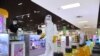 FILE - This undated picture released from North Korea's official Korean Central News Agency (KCNA) on July 2, 2022, shows a worker disinfecting to stop the spread of COVID-19 in a Pyongyang shop.