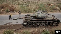 Des agriculteurs passent à côté d'un char abandonné le long de la route à Dansa, au sud-ouest de Mekele dans la région de Tigray, en Éthiopie, le 20 juin 2021 .