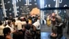 Les visiteurs se tiennent debout pour voir des objets pillés par les soldats coloniaux français retournés et exposés au grand public lors d'une exposition à la présidence à Cotonou, la capitale du Bénin, le 20 février 2022.
