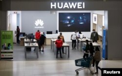 Wateja na wafanyakazi wakiwa katika duka la Huawei katika eneo la biashara la Sandton City, Sandton, Afrika Kusini, Feb. 16, 2022.