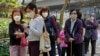 People wearing protective face masks line up to receive a dose of China's Sinovac COVID-19 coronavirus vaccine at a community vaccination center in Hong Kong, March 3, 2022.