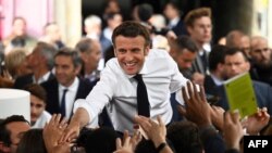 El presidente francés Emmanuel Macron, estrecha la mano de sus partidarios durante un mitin de campaña, en Figeac, sur de Francia, el 22 de abril de 2022.