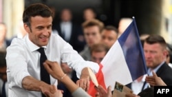 Emmanuel Macron serre la main de ses partisans lors d'un rassemblement le dernier jour de la campagne, à Figeac, dans le sud de la France, le 22 avril 2022.