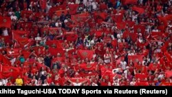 Les supporters marocains brandissent des drapeaux lors de la seconde moitié d'un match de demi-finale contre la France lors de la Coupe du monde 2022 au stade Al Bayt.