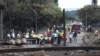 Des gens se rassemblent près d'un camion incendié à l'entrée du pont endommagé où un pétrolier a explosé à Boksburg près de Johannesburg, Afrique du Sud, le 24 décembre 2022.
