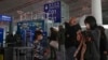 FILE - Passengers wearing face masks line up for a security check to enter a departure gate at Beijing Capital International Airport, in Beijing, China, Dec. 29, 2022.