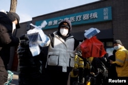 藥房外排大隊，北京快遞小哥在藥房取藥後準備遞送。 （2022年12月7日）