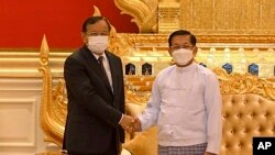 In this photo provided by the Military True News Information Team, Myanmar State Administration Council Chairman Senior General Min Aung Hlaing, right, shakes hands with Cambodian Foreign Minister and ASEAN Special Envoy to Myanmar Prak Sokhonn during a meeting in Naypyitaw.