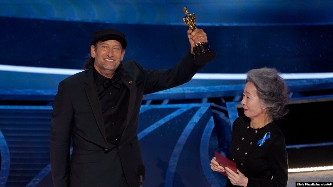 Youn Yuh-jung, a la derecha, entrega a Troy Kotsur el premio a la mejor interpretación de un actor en un papel secundario por "CODA" en los Oscar el domingo 27 de marzo de 2022 en el Dolby Theatre de Los Ángeles. (Foto AP/Chris Pizzello)