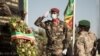 Le président malien de transition, le colonel Assimi Goïta (à droite) regarde après avoir déposé une gerbe sur le monument aux morts, lors de la cérémonie célébrant la fête nationale de l'armée, à Kati, le 20 janvier 2022. (Photo par FLORENT VERGNES / AFP ) 
