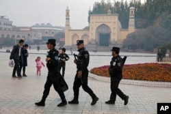រូបឯកសារ៖ ក្រុម​សន្តិសុខ​ Uighur ​ដើរ​ល្បាត​នៅ​ជិត​វិហារ​ឥស្លាម​ Id Kah ក្នុង​ទីក្រុង​ Kashgar ក្នុង​តំបន់​ស្វយ័ត​ស៊ីជាង។