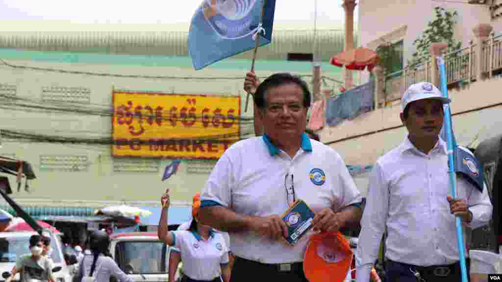 លោក យ៉ែម បុញ្ញឫទ្ធិ ប្រធានបក្សកម្ពុជានិយម ដើរចែកខិតបណ្ណគោលនយោបាយបក្សទៅឱ្យប្រជាពលរដ្ឋ នៅក្នុងផ្សារប៉េសេ សង្កាត់បឹងទំពន់ទី ២ រាជធានីភ្នំពេញ ថ្ងៃទី ២៩ ខែឧសភា ឆ្នាំ ២០២២។ (លាស់ លីបលីប/វីអូអេ)
