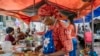Une femme sert un thieboudiene, également connu sous le nom de Ceebu Jën (littéralement "riz au poisson" en wolof) près du marché de Kermel à Dakar le 14 décembre 2021. (Photo CARMEN ABD ALI / AFP)