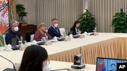 FILE - In this photo taken May 24, 2022, and released by her office, U.N. High Commissioner for Human Rights Michelle Bachelet, second from left, holds a virtual meeting with Vice Minister Du Hangwei of the Ministry of Public Security, seen on screen at right, in Guangzhou, southern China's Guangdong province.