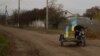 Учитель Юрій Невольчук їде на мотоциклі з українськими прапорами в селі Благодатне, відвойованому ЗСУ на Херсонщині, 11 листопада 2022 року. REUTERS/Валентин Огіренко