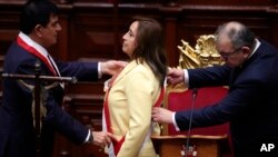 L'ancienne vice-présidente Dina Boluarte reçoit l'écharpe présidentielle après avoir prêté serment en tant que nouvelle présidente au Congrès à Lima, au Pérou, mercredi 7 décembre 2022. 