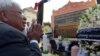 FILE - Chhang Song, former information minister, prays in front of a memorial to dozens of foreign and local journalists killed covering the country's 1970-75 war that was won by the communist Khmer Rouge regime in Phnom Penh, Cambodia, February 6, 2013.