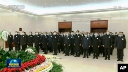2022年12月5日，中國中央電視台播放的視頻截圖中，中國國家主席習近平和前任胡錦濤與其他領導人一起向前國家主席江澤民的遺體表示敬意。