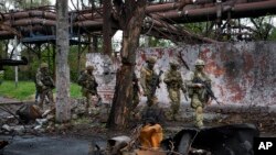 ARCHIVES - Des troupes russes à Marioupol, un territoire sous le gouvernement de la République populaire de Donetsk, dans l'est de l'Ukraine, le 18 mai 2022.