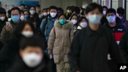 資料照 - 2022年12月20日的北京街頭，帶口罩的通勤者在交通高峰期匆忙趕去上班。在突然放開了執行將近3年的嚴格封控政策後，中國多地新冠感染病例暴增，並且出現了奧密克戎病毒的變異毒株。