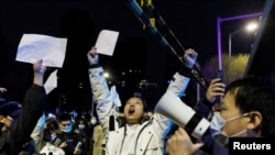 資料圖：2022年11月28日，在新冠病毒疫情持續擴散之際，北京民眾為烏魯木齊火災罹難者守夜後，舉著白紙抗議中共當局的封鎖限制。