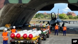 台灣軍隊士兵站在F16V戰機前，準備進行裝載美製AGM-84魚叉反艦導彈及AIM-120和AIM-9空空導彈的訓練。（2022年9月16日）