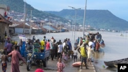 Des personnes bloquées par des inondations suite à plusieurs jours de pluies diluviennes à Kogi, au Nigeria, le 6 octobre 2022. Plus au sud, dans l'État voisin d'Anambra, 85 personnes se trouvaient sur un bateau lorsqu'il a chaviré, le 7 octobre 2022.