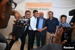 FILE - Conservative leadership candidate Rishi Sunak meets audience members during a Conservative Friends of India event at the Dhamecha lohana center in Harrow, London, Aug. 22, 2022.