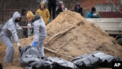Архівне фото: Особи в захисному спорядженні, проводять ексгумацію тіл цивільних, вбитих під час російської окупації Бучі, Київщина, 13 квітня 2022 року