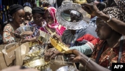 Des femmes achètent des bols et des assiettes sur un marché du centre historique de Rufisque, le 3 avril 2022, le premier jour du Ramadan.
