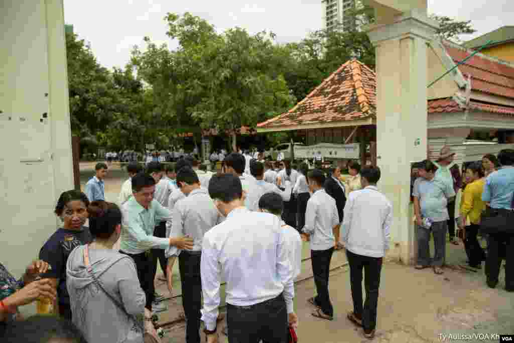 បេក្ខជនប្រឡងឈរតំរង់ជួរមុខមណ្ឌលប្រឡងដើម្បីធ្វើការឆែករកសំណើរឯកសារមុនចូលមណ្ឌលប្រឡង។ នៅរាជធានីភ្នំពេញ ថ្ងៃចន្ទ ទី២០ ខែសីហា ឆ្នាំ២០១៨។ (ទី អូលីស្សា/VOA)