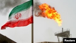 Un drapeau iranien vole au dessus d'une production de pétrole, en Iran, le 25 juillet 2005.