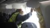 FILE - NTSB Investigator-in-Charge John Lovell examines the fuselage plug area of an Alaska Airlines flight after an emergency landing in Portland, Oregon, Jan. 7, 2024. (National Transportation Safety Board via AP)