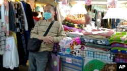台北夜市一商販販假口罩等待顧客。（2020年2月6日）