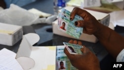 Un responsable de la Commission électorale nationale indépendante (INEC) trie les cartes d'électeur permanent (PVC) des électeurs dans un quartier de Lagos, au Nigeria, le 12 janvier 2023.