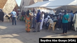 Une centaine de personnes font la queue pour accéder à la salle d'enrôlement à Dakar, au Sénégal, le 14 septembre 2018. (VOA/Seydina Aba Gueye)