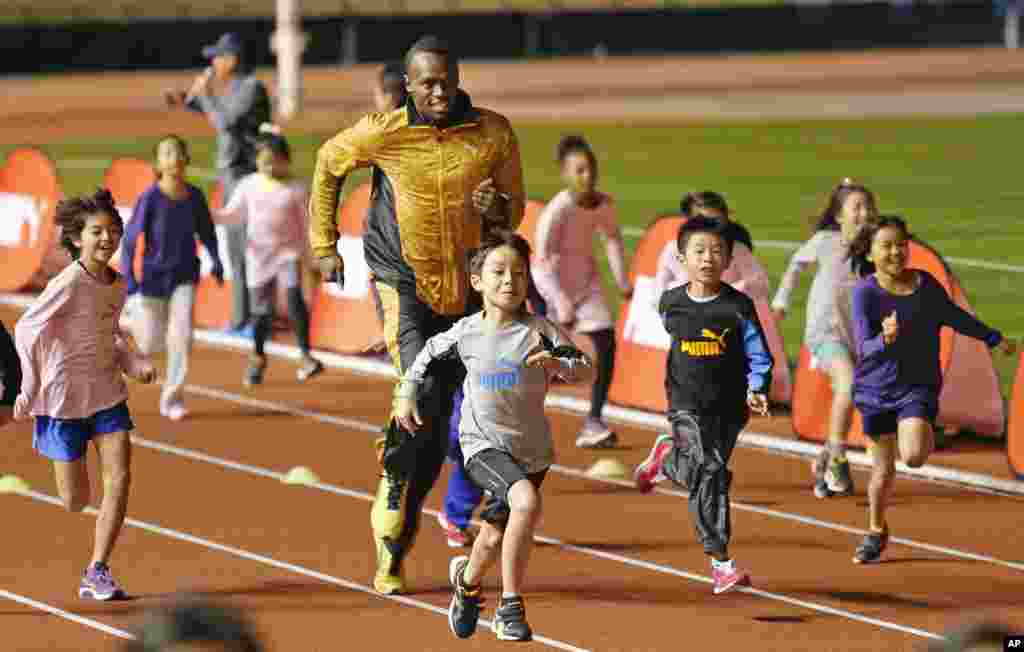 usain Bolt fait une compétition avec des enfant à Tokyo, Japon, le 22 November 2013.