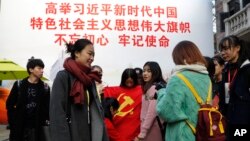 一群大學生手舉中共黨旗在寫有“習近平語錄”的宣傳板前合影。 （2017年11月19日）