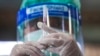 A health worker prepares a dose of the Sinovac COVID-19 vaccine for people who live in a popular market area where a new cluster of COVID-19 infections was found in Bangkok, Thailand, March 17, 2021. 