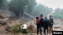 Les gens regardent les dégâts causés par le cyclone Freddy à Chilobwe, Blantyre, Malawi, le 13 mars 2023. 