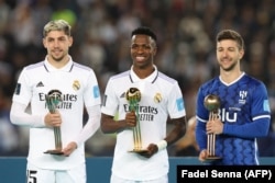 Le Brésilien Vinicius Junior (au centre), l'Uruguayen Federico Valverde, et l'attaquant argentin de Hilal, Luciano Vietto, avec leurs trophées individuels au stade Prince Moulay Abdellah de Rabat, le 11 février 2023.