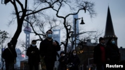 上海不斷出現新冠病例後，行人戴著口罩行走在上海街頭。（2022年2月14日）
