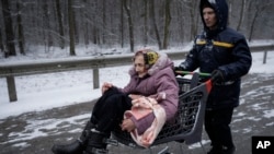 一位老年婦女坐在購物車中被轉移出基輔附近的伊爾平。 (2022年3月8日)