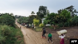 Des personnes fuient le lieu d'une attaque attribuée aux combattants ADF dans le village de Halungupa près de Beni en RDC, le 18 février 2020. AFP / Alexis Huguet